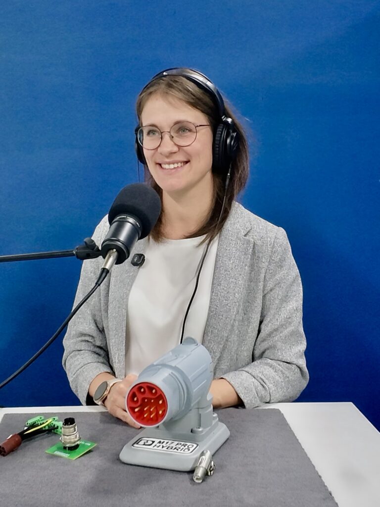 Lisa Gärttner im Podcaststudio mit einem vergrößerten Anschauungsmodell des M17 PRO Hybrid.